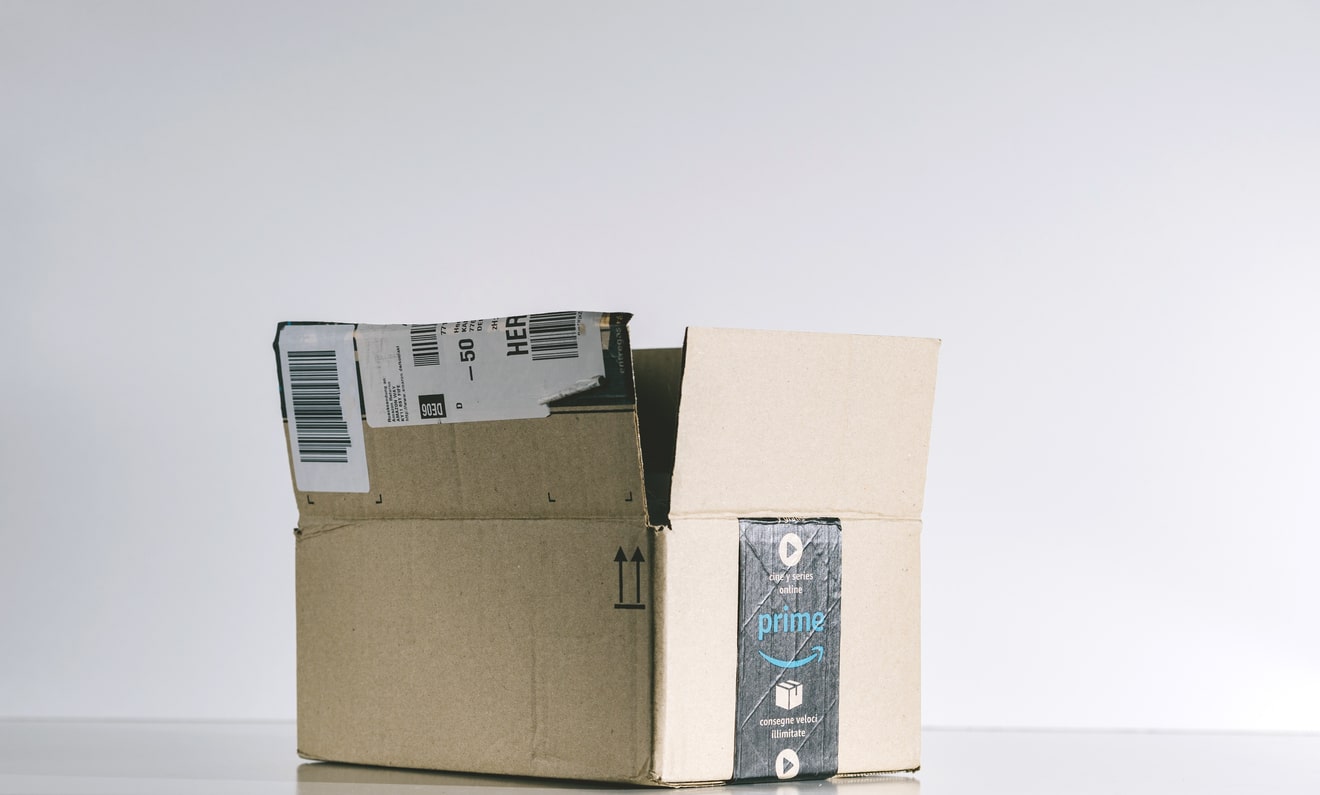 Paris: Open Amazon Prime cardboard box side. Amazon is an American electronic e-commerce company distribution worlwide e-commerce goods